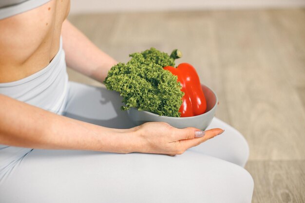 写真 皿の上に健康的な新鮮な野菜をたくさん持っている女性のカットされた写真