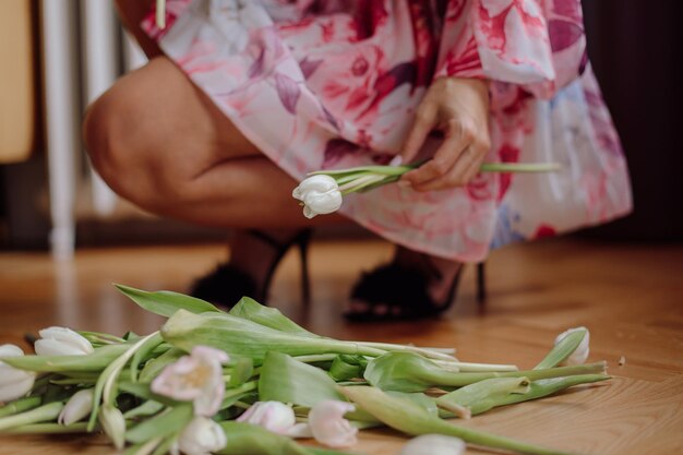 Cropped photo of woman wearing bright colorful pink dress holding amazing white tulip gathering flow