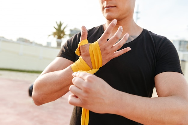 Cropped photo of young strong sports man boxer