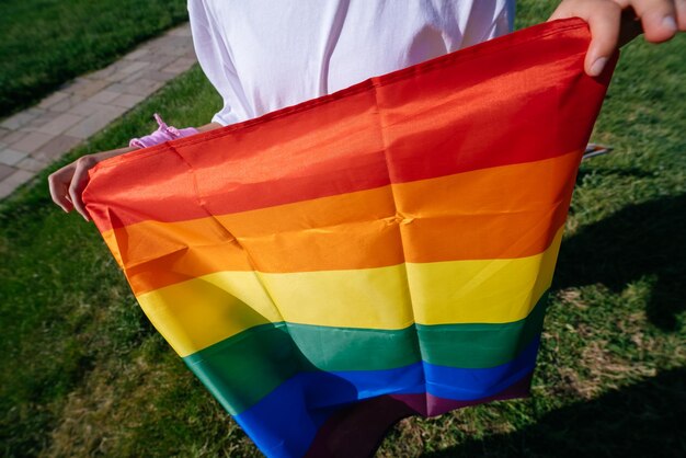 Cropped photo of young woman with LGBT pride flag