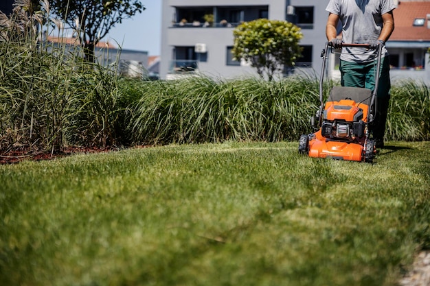 Cropped picture of a man cutting grass with a lawn mower