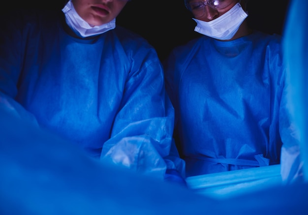 Обрезанное изображение скальпеля, сделанное врачами, проводящими операцию