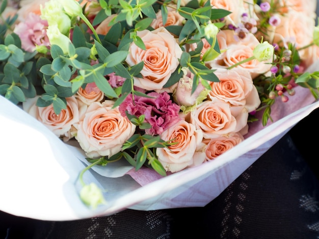 Cropped picture of Woman legs with rose bouquet selective focus