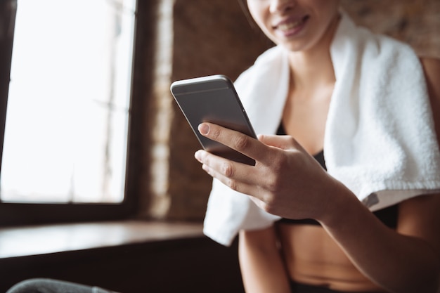 Photo cropped picture of young fitness woman chatting by phone.