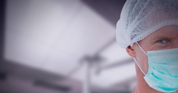 백그라운드에서 병원에 얼굴 마스크를 쓰고 백인 남성 외과의 자른 초상화