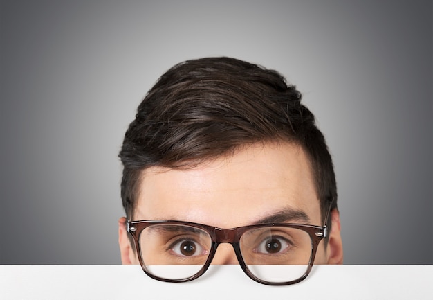 Cropped portrait of handsome young man in glasses looking at camera