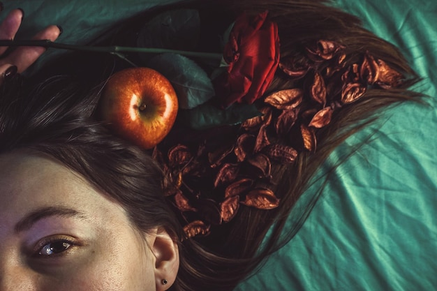 Photo cropped portrait of woman with apple and rose