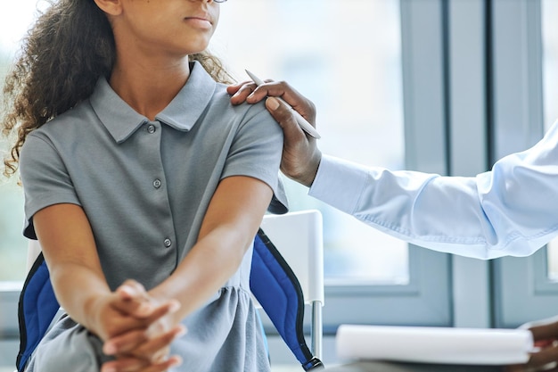 Cropped portrait of young black girl in therapy session with male psychologist supporting