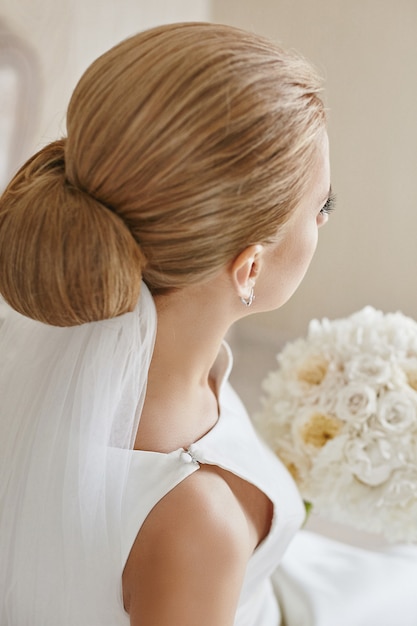 Cropped portrait of a young woman with blond hair and wedding coiffure