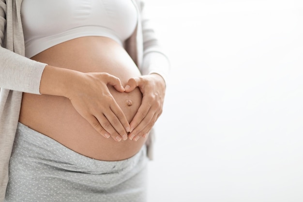 Cropped of pregnant woman holding hands on big belly