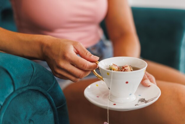 Cropped shoot of an unrecognizable  woman enjoying cup of herbal tea during treatment in a beauty spa salon.