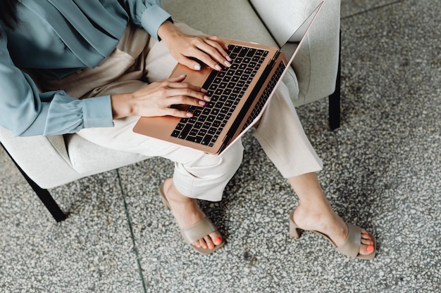 Foto colpo ritagliato di una bella donna asiatica che lavora con il laptop sul divano