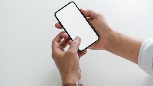 Cropped shot of businessman touching on phone in on white table