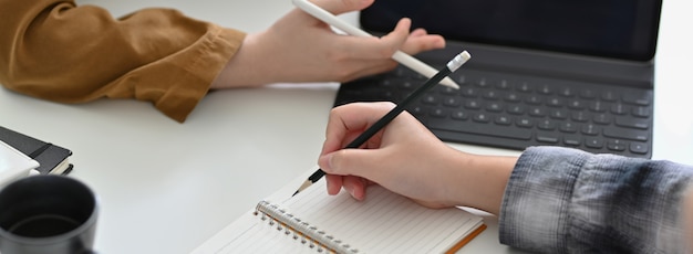 Cropped shot of businesspeople consulting on their project on white office desk