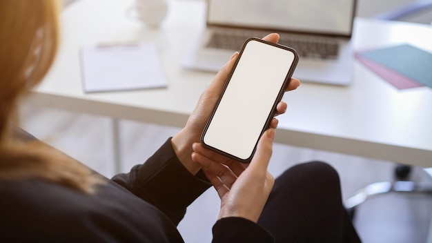 Cropped shot of businesswoman working with smartphone at her office desk