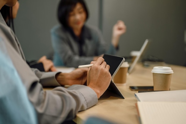 Cropped shot of businesswoman writing notes on digital tablet at boardroom table