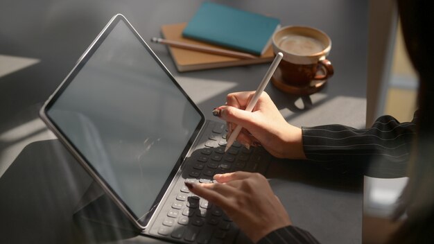 Photo cropped shot of businesswomen working on blank screen tablet