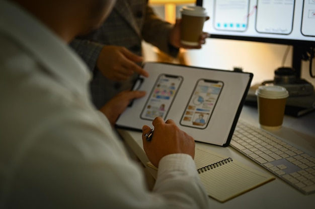 Photo cropped shot of developers team working on new website wireframe at office