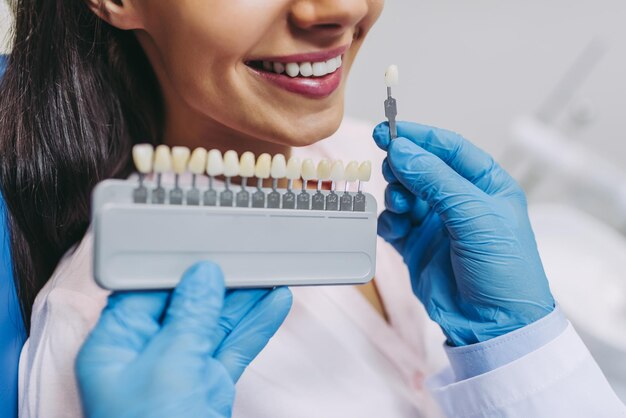 Cropped shot of doctor and patient choosing tooth implants in modern dental clinic