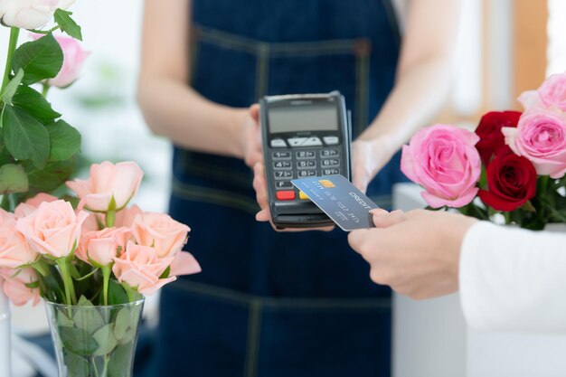 Cropped shot of female florist giving credit card to customer