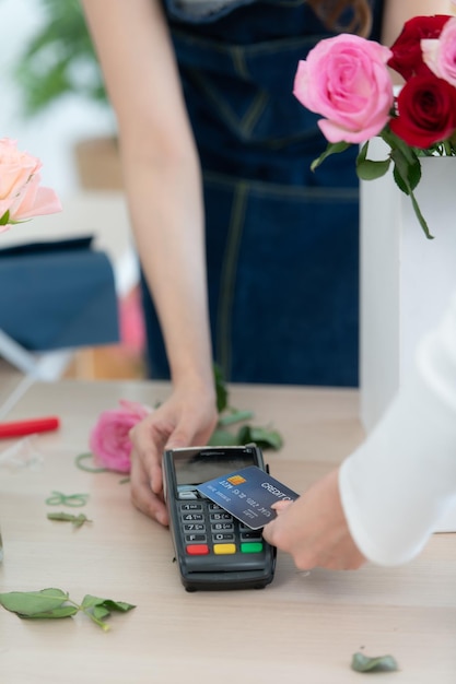 Cropped shot of female florist giving credit card to customer