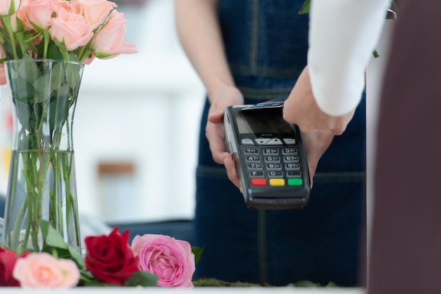 Cropped shot of female florist giving credit card to customer