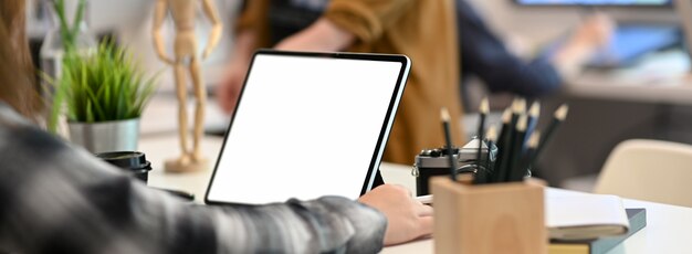 Cropped shot of female graphic designer working on tablet on withe table