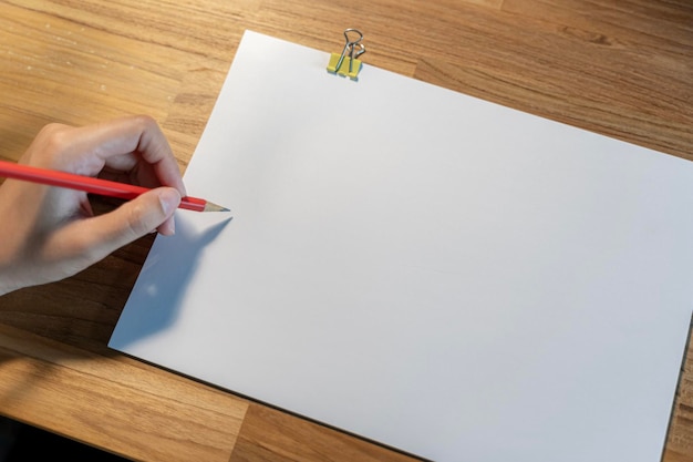 Photo cropped shot of female hand writing on blank notebook while working table working place and planning concept top view