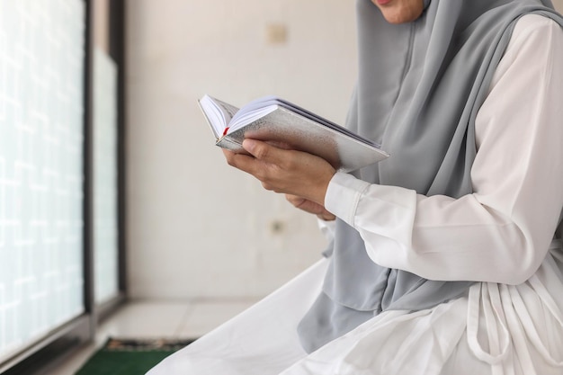 Cropped shot of female muslim reading Quran at the mosque