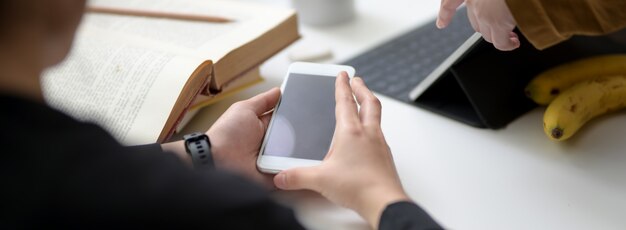 Cropped shot of female university student using smartphone to find informations