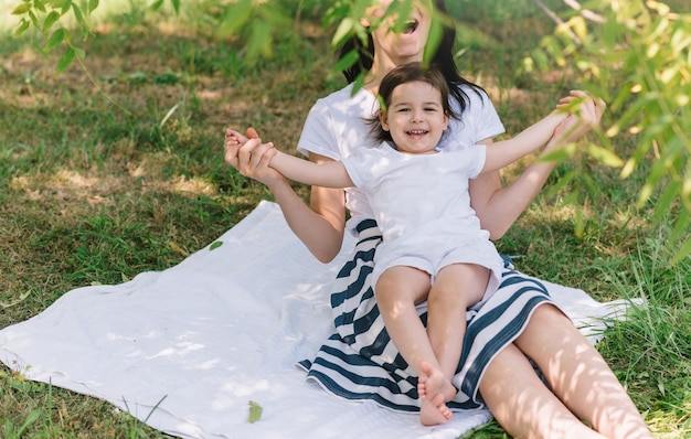 Cropped shot of fun happy smile and laughing daughter child play with mom in the park outdoor Portrait of happy family Happy Mothers Day Motherhood and childhood