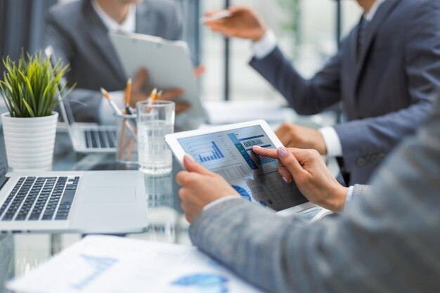 Photo cropped shot of a group of businesspeople looking at graphs on digital tablets