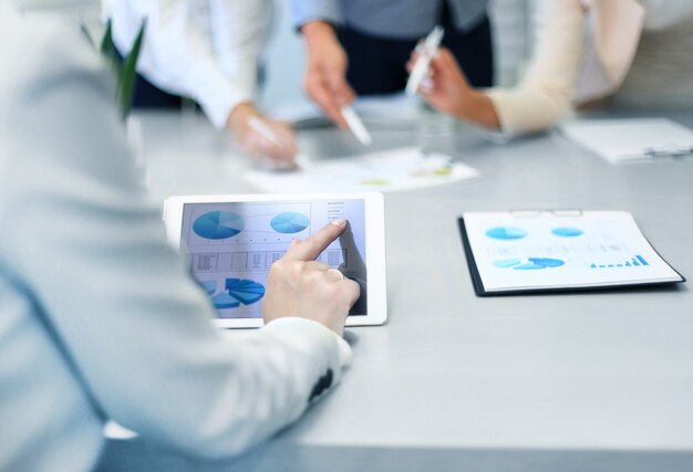 Photo cropped shot of a group of businesspeople looking at graphs on digital tablets