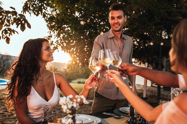 Cropped shot of handsome friends having dinner in the backyard