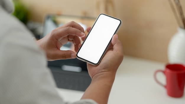 Cropped shot of male designer touching blank screen smartphone