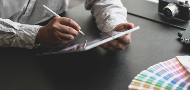 Cropped shot of male designer working on his project with tablet