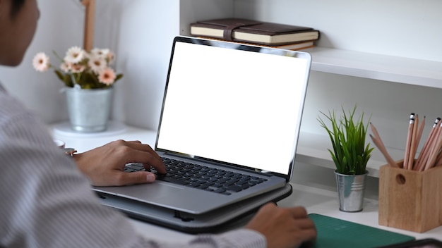 Cropped shot of male freelancer is working with computer laptop at his creative workspace.