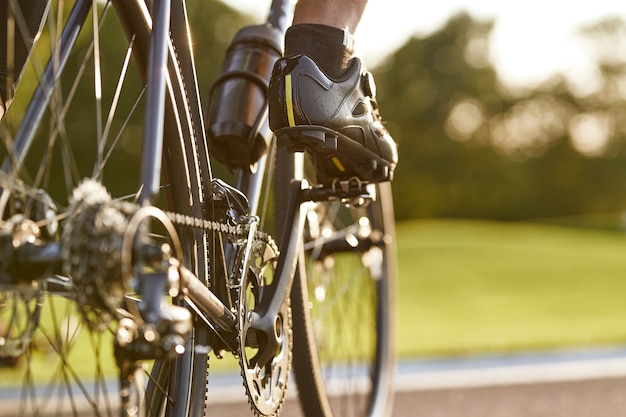 Cropped shot of a man cycling outdoors focus on male legs