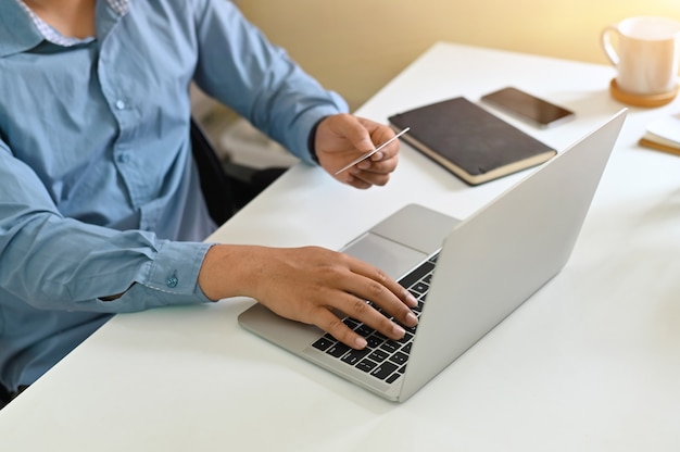 Cropped shot of man input credit card information while shopping online.