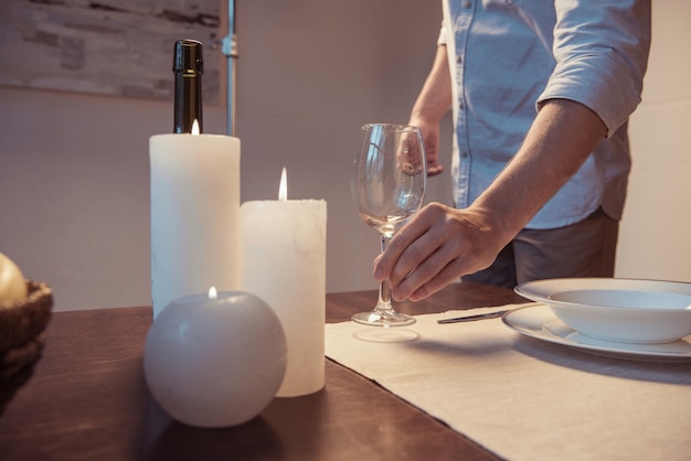 Cropped shot of man serving table for romantic dinner