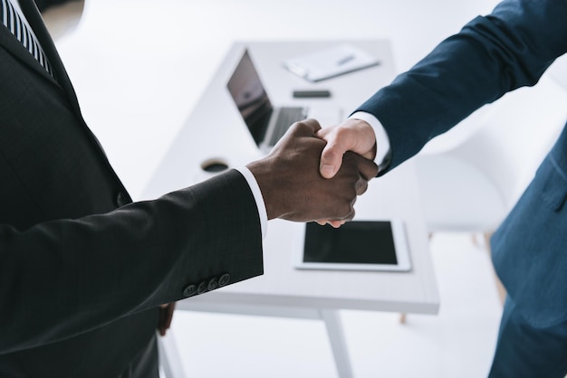 Cropped shot of multicultural businessmen shaking hands after business meeting