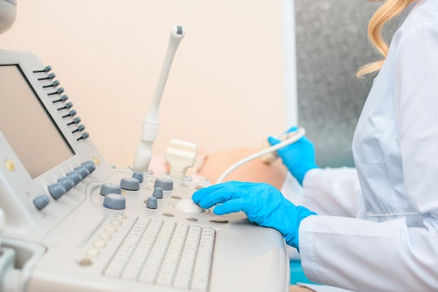 Cropped shot of obstetrician gynecologist making ultrasound examination for pregnant woman