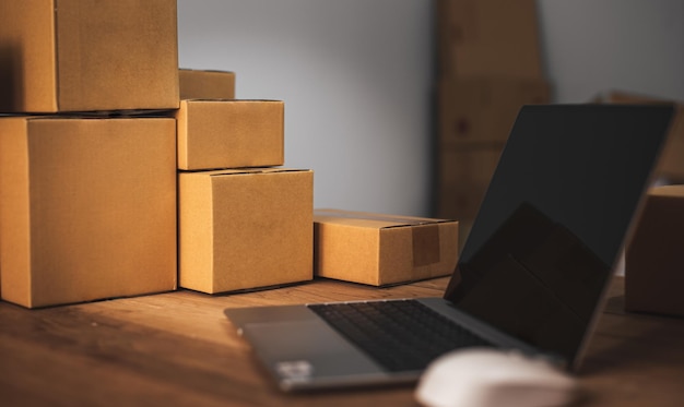 Cropped shot of portable office desk with mockup computer devices supplies and decorations on wood