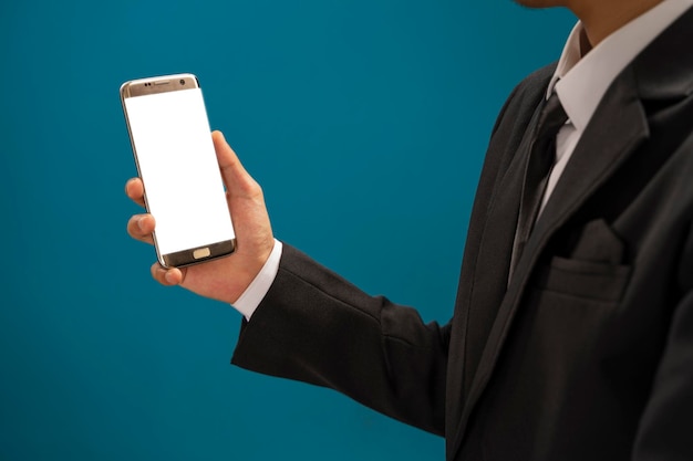 Cropped shot of professional businessman holding blank screen smartphone on blue background