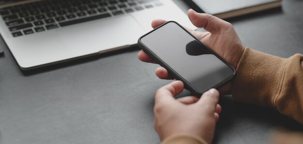 Cropped shot of professional businessman holding smartphone