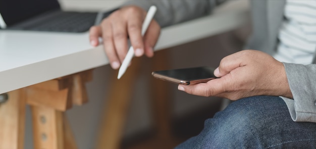 Cropped shot of professional businessman using his smartphone