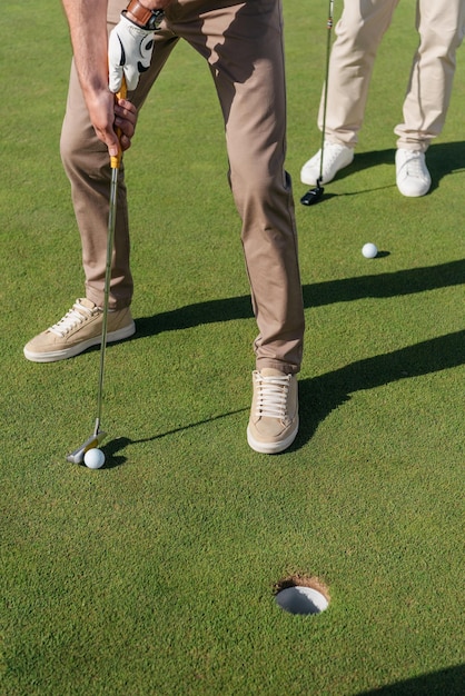 Cropped shot of professional golf players getting ready to shot a ball