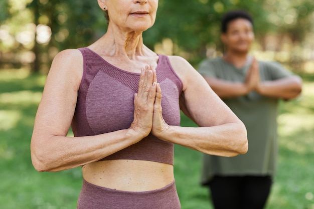 Cropped shot of senior woman enjoying yoga outdoors