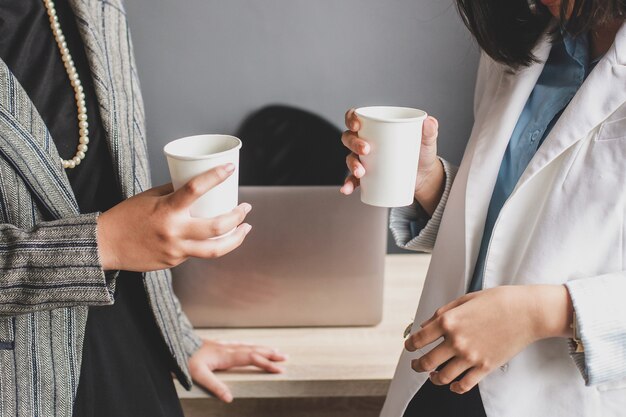 Photo cropped shot of two business woman have a coffee time at the office