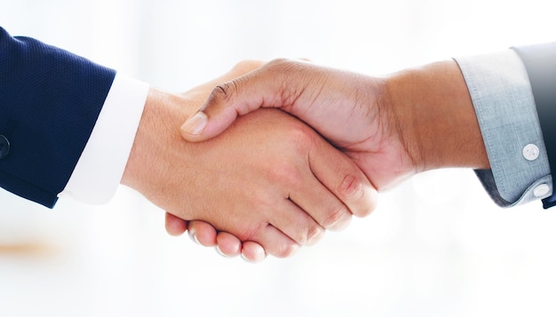 Cropped shot of two businessmen shaking hands in a modern office